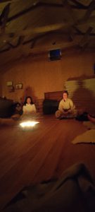 Människor i en mysig yogasal med levande ljus